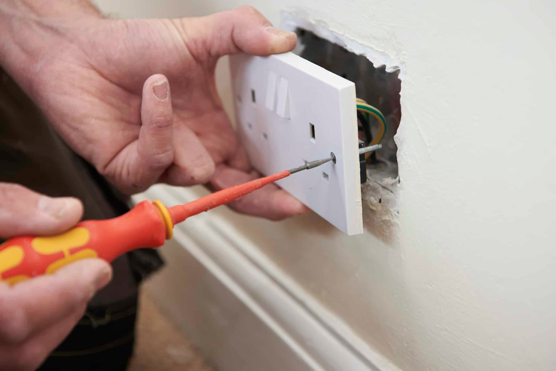 Fitting a new white double socket faceplate to a wall